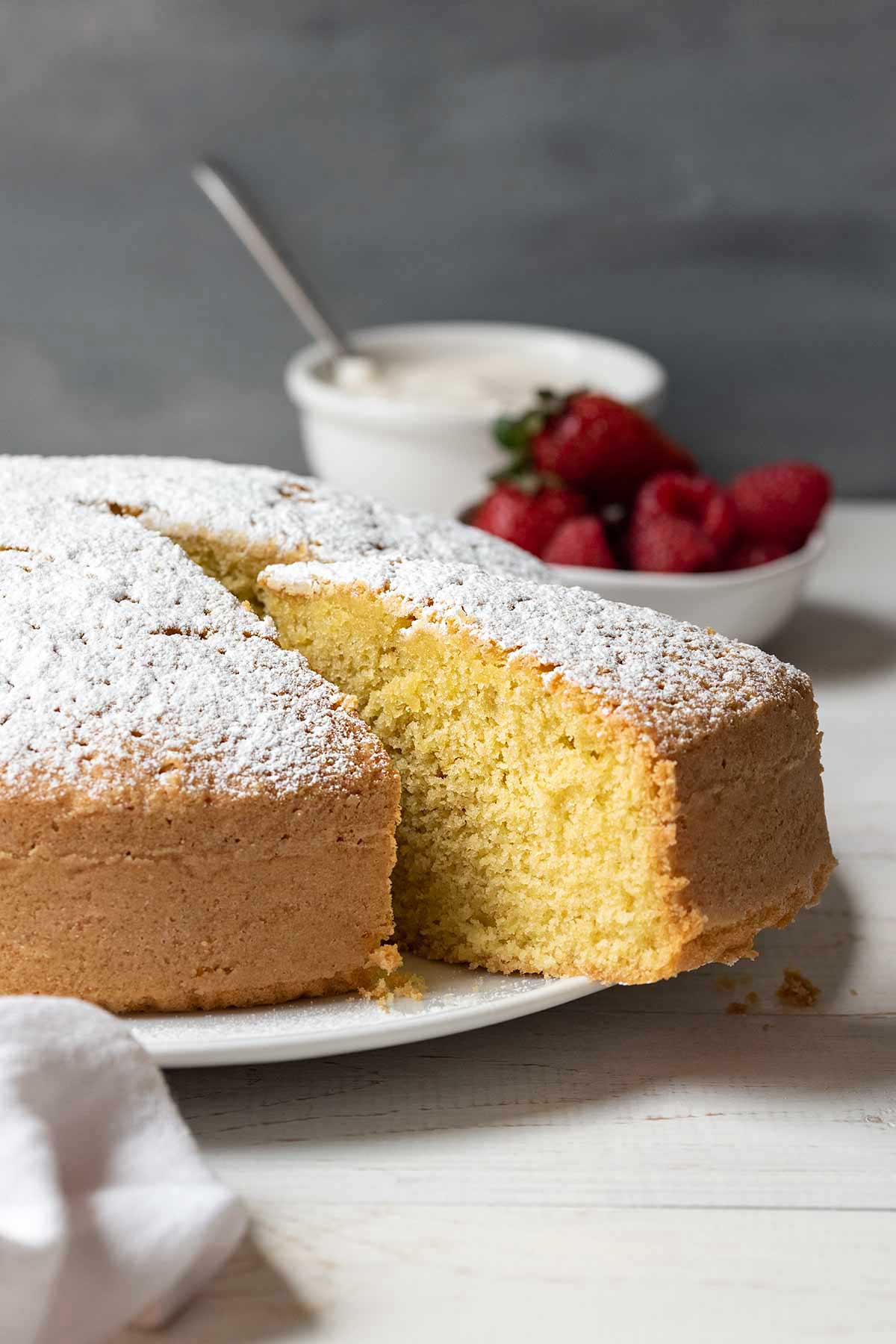 Sliced lemon olive oil cake on a plate.