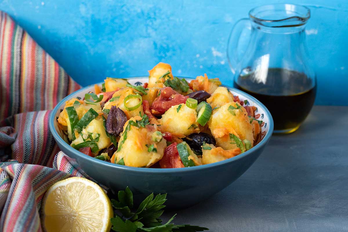 Image showing a bowl with potato salad, a lemon wedge and a jug with olive oil.