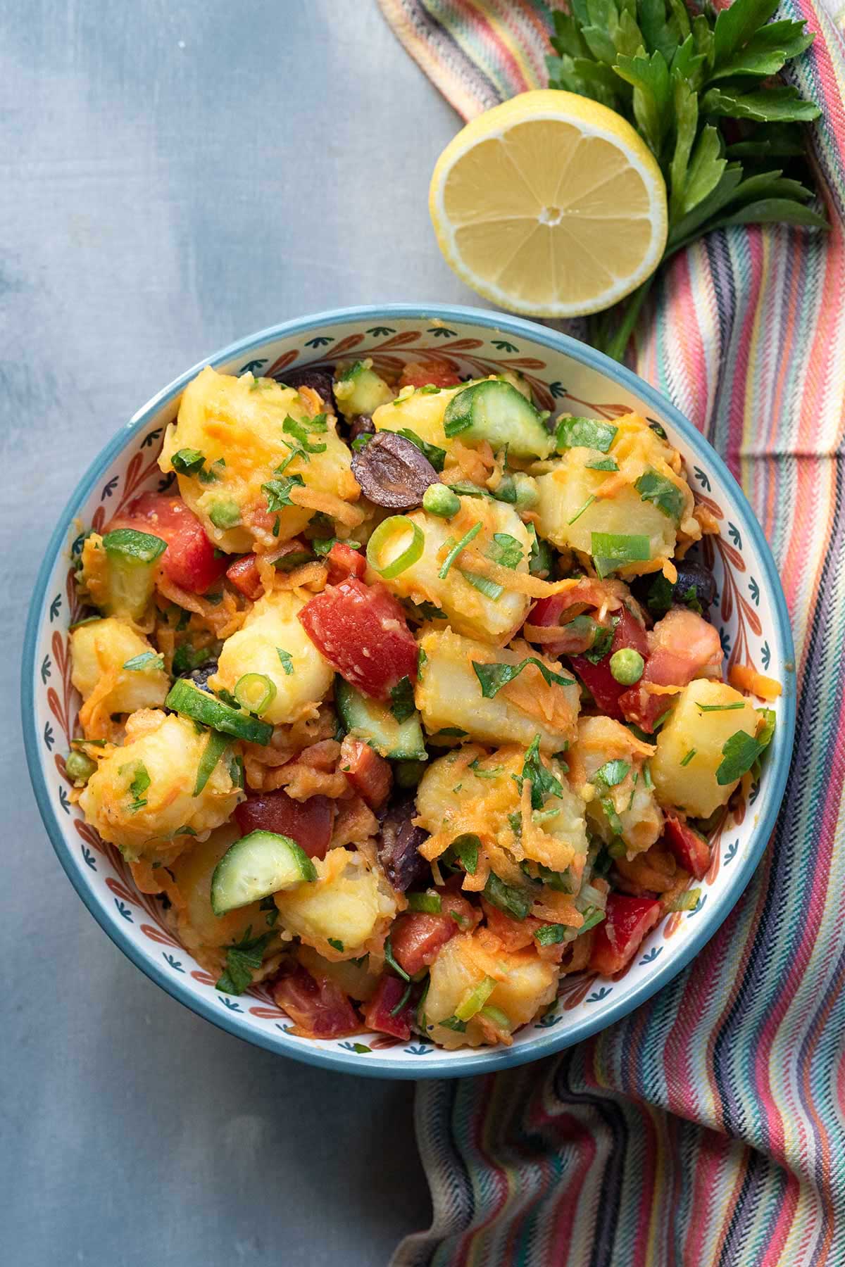 Image of a Greek potato salad in a bowl. Vertical shot.