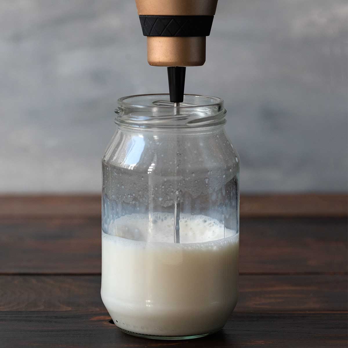 Frothing milk in a jar with a milk frother.