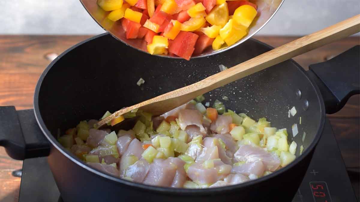 Chicken breast and chopped bell peppers added to the pot.