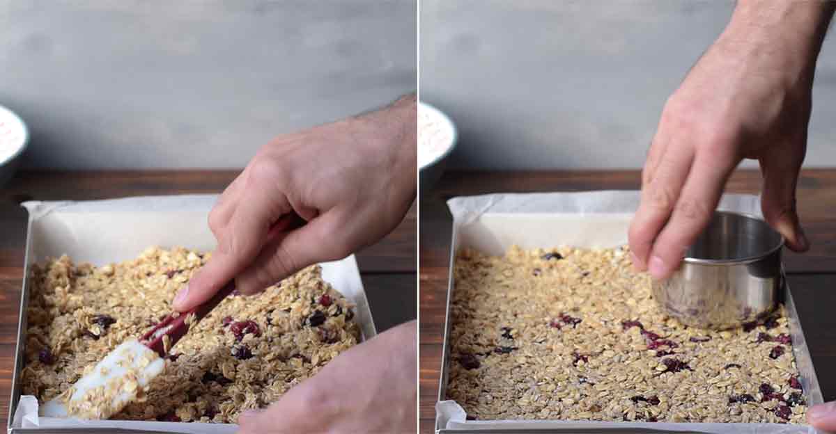 A hand leveling and pressing the oat bar mixture into the baking dish.