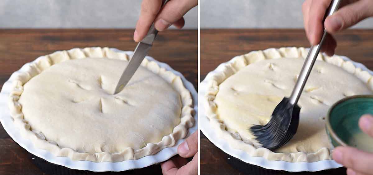 A hand making holes to the surface of the chicken pot pie and brushing it with milk.