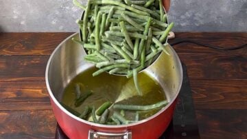 Green beans in a pot with olive oil.