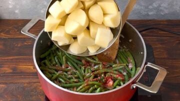 Adding potatoes to the pot.