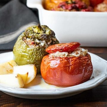 A stuffed tomato and pepper on a plate.