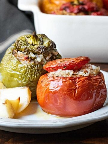 A stuffed tomato and pepper on a plate.
