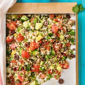 A tray with lentil and bulgur salad with chopped vegetables.