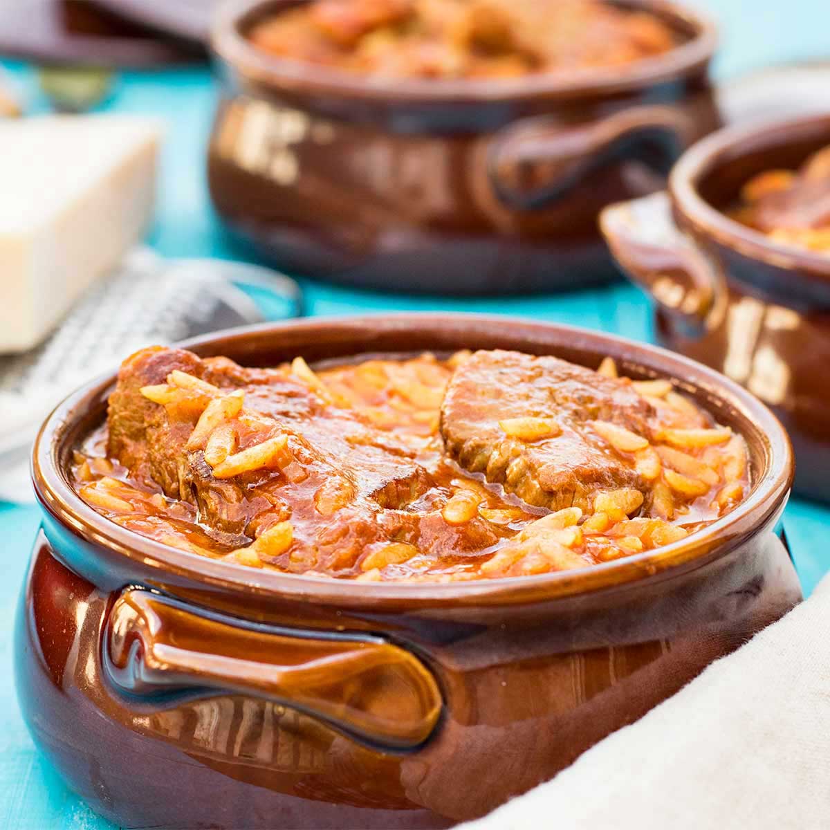 Greek beef stew with orzo pasta served inside a traditional dish.
