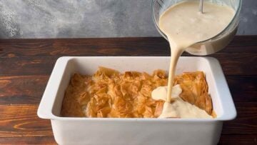 Pouring the custard mixture over the baked phyllo.