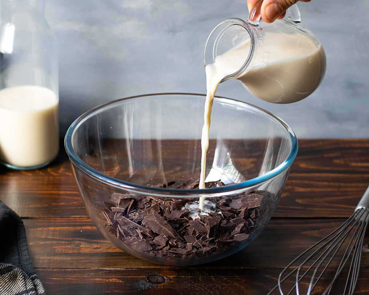 Adding the hot milk to the chopped chocolate.