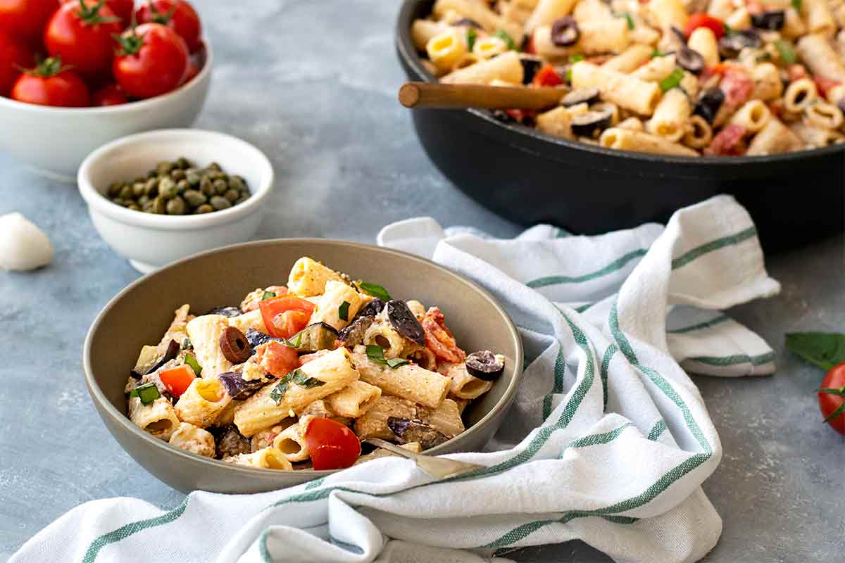 A bowl with summer pasta with eggplant and tomato.