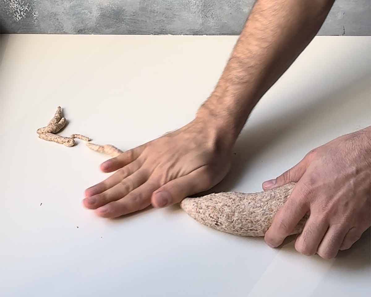 A hand kneading the dough.