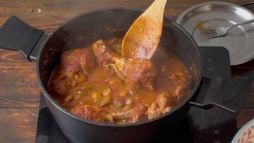 Returning the chicken to the pot.