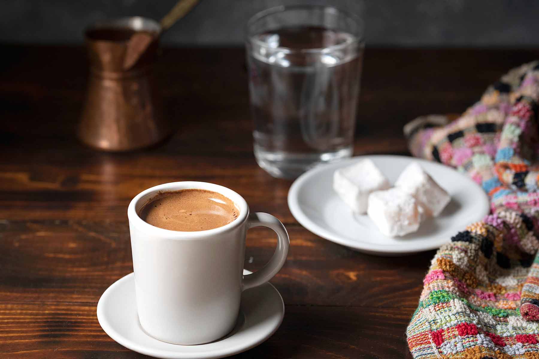 A cup of Greek coffee served with turkish delights.