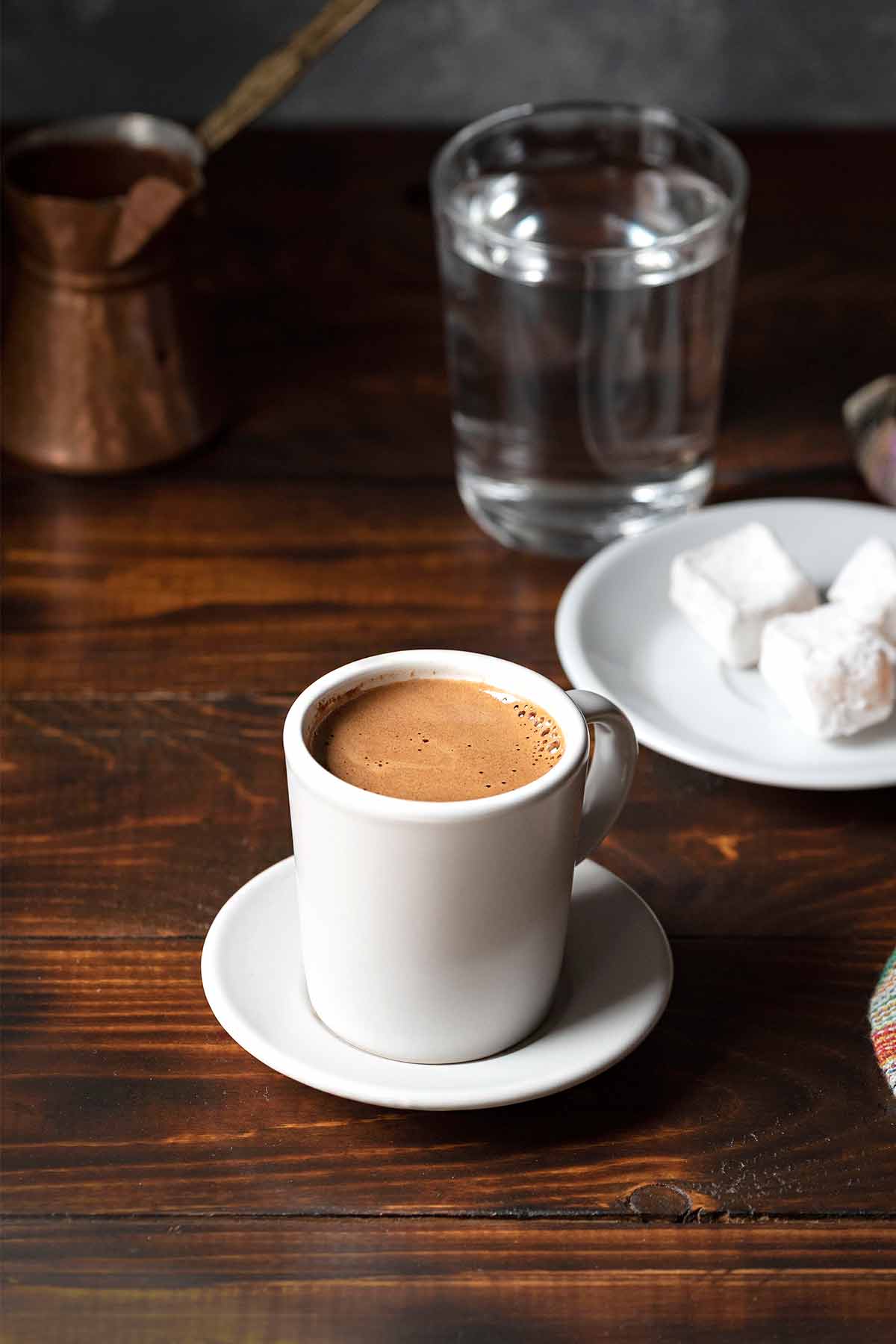 Greek coffee in a cup, a briki and turkish delights.