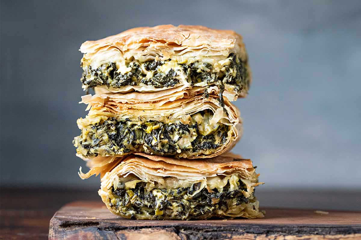 Spanakopita slices onto a cutting board.