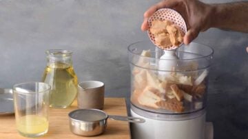 Adding tarama (fish roe) to a food processor.