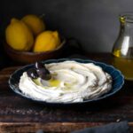 taramasalata on a plate garnished with olives.