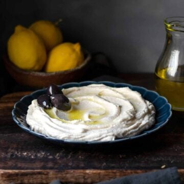 taramasalata on a plate garnished with olives.