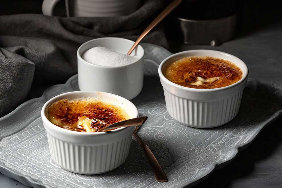 Ramekins with creme brulee with a cracked surface.