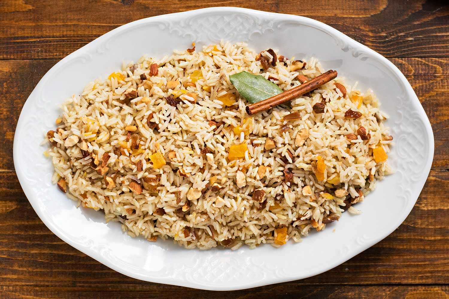 Moroccan rice with raisins and nuts served on a large plate.