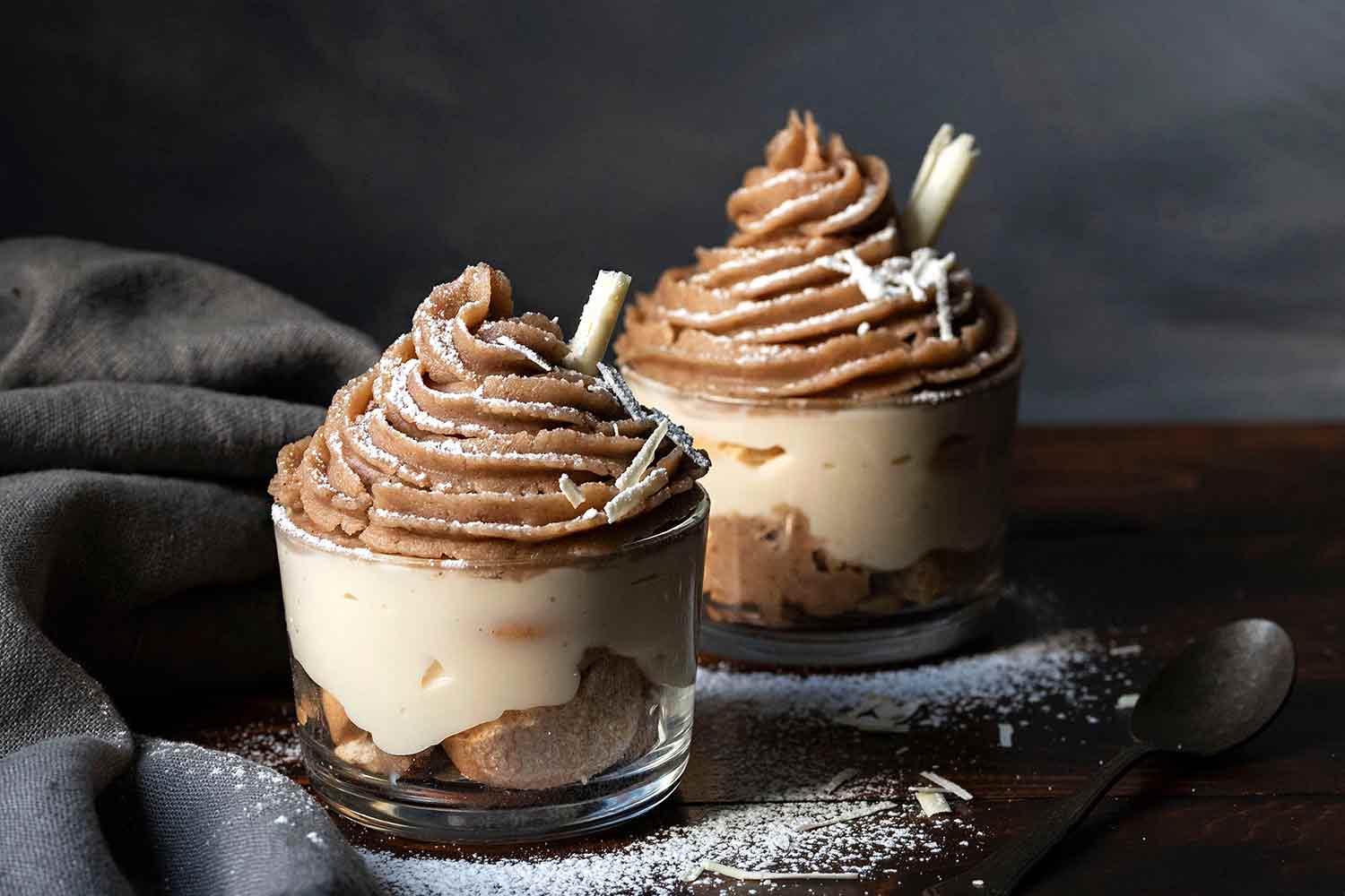 Mont Blanc dessert in two glasses topped with white chocolate curls.