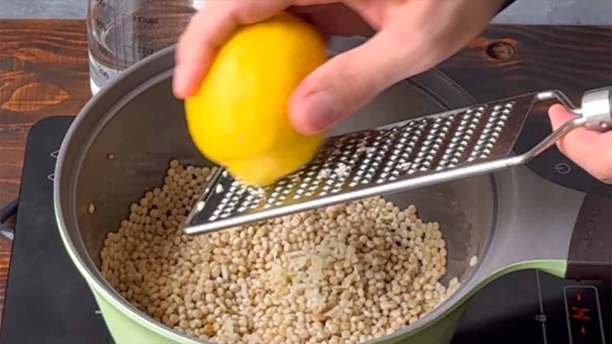 Zesting the lemon with a zester.
