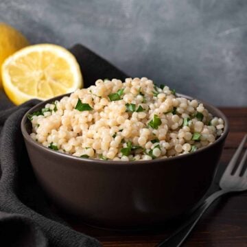 A bowl with lemon garlic pearled couscous.