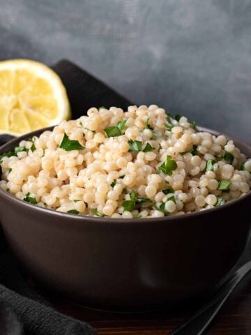 A bowl with lemon garlic pearled couscous.
