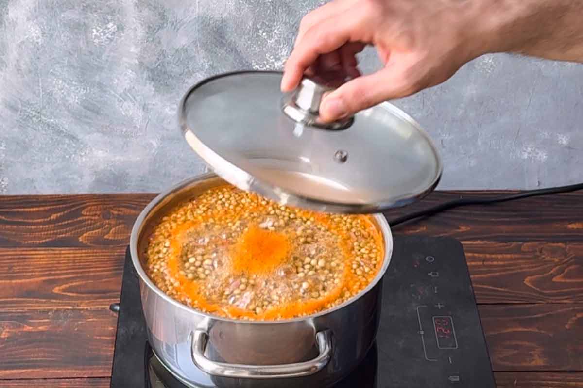 A hand closing the pot with the lid.