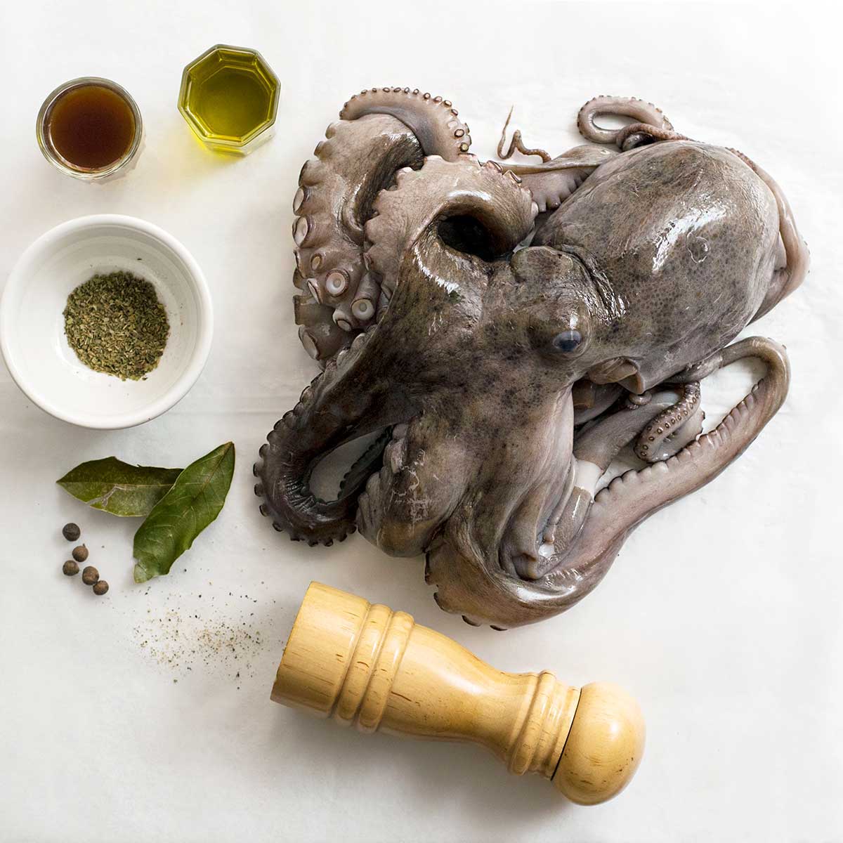 Fresh octopus prepared for the oven on a piece of parchment paper.