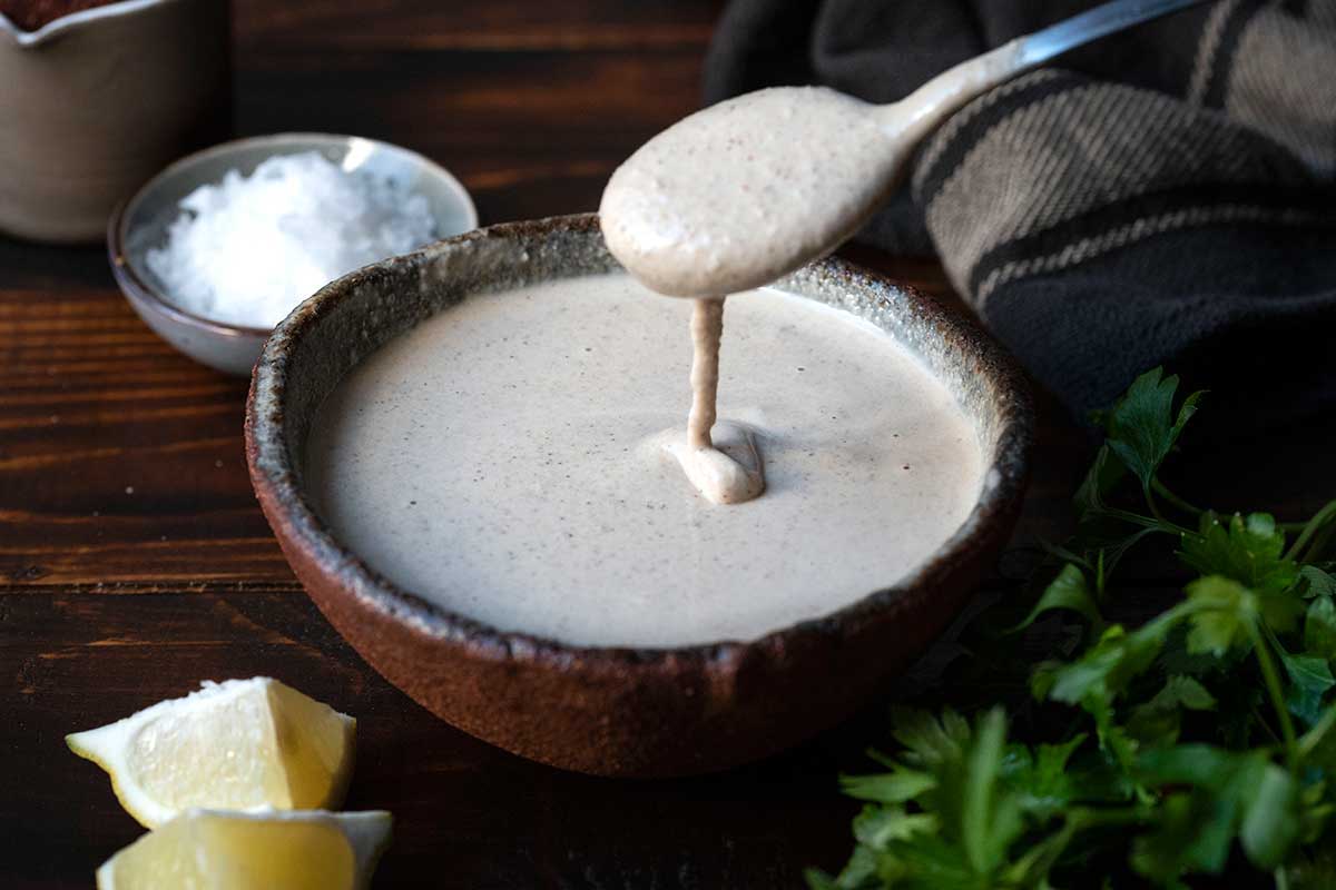 Image showing a bowl of tahini sauce as a dairy-free Greek yogurt substitute.