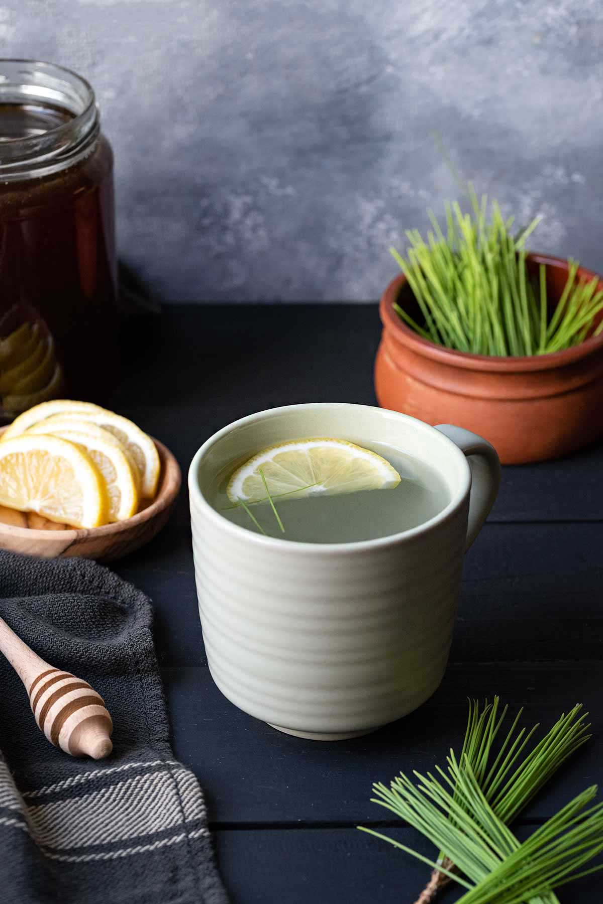 Pine needle tea in a cup with a slice of lemon.