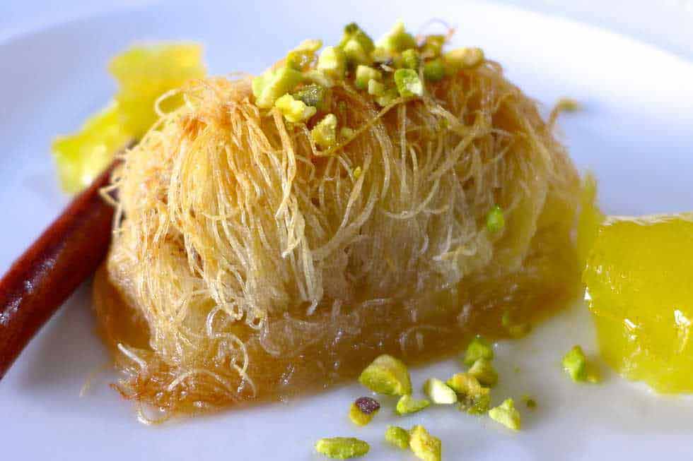 Kataifi roll with sugar syrup on a plate.