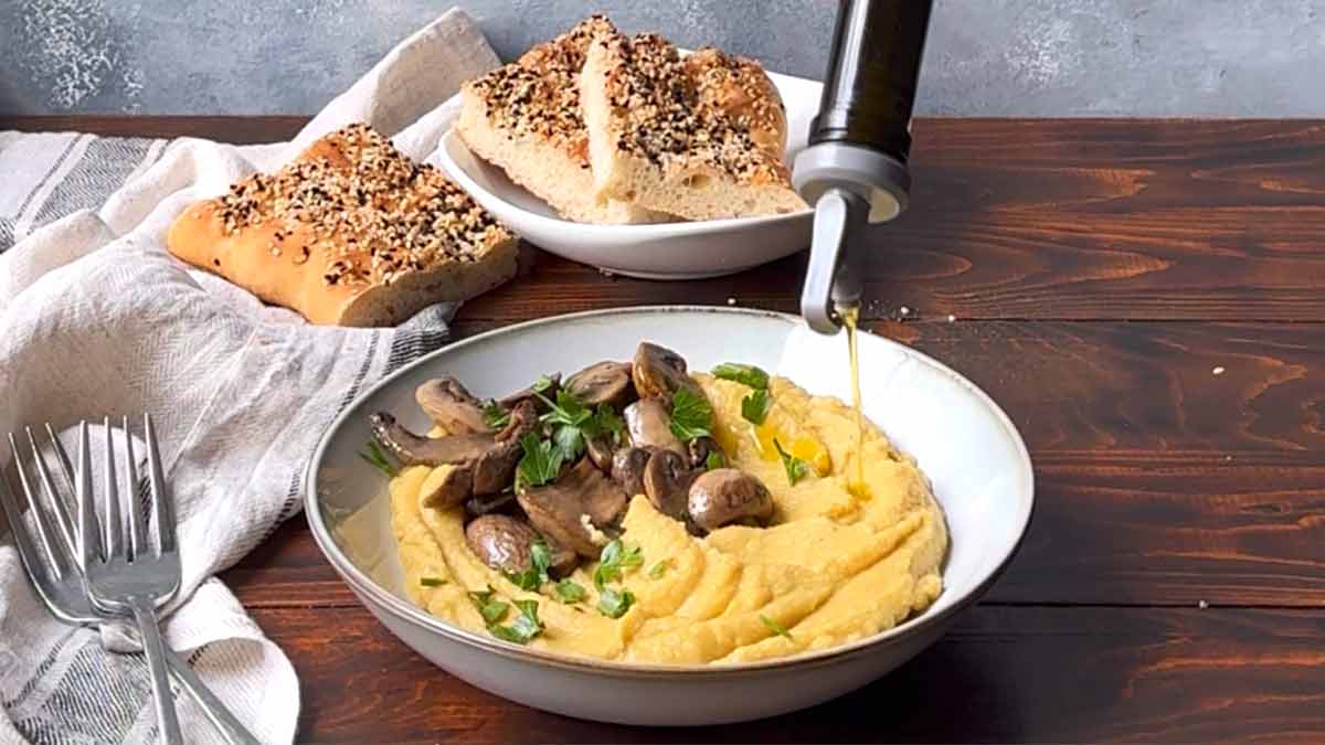 Drizzling olive oil over a plate with Greek fava.
