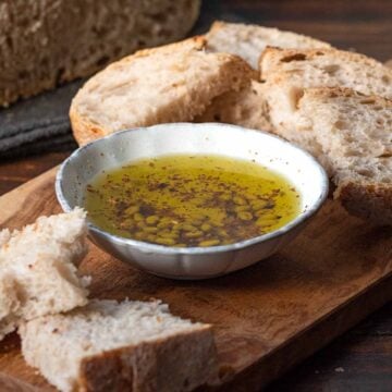 A bowl with olive oil and slices of crusty bread. Featured image.