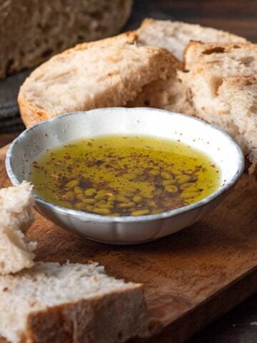 A bowl with olive oil and slices of crusty bread. Featured image.