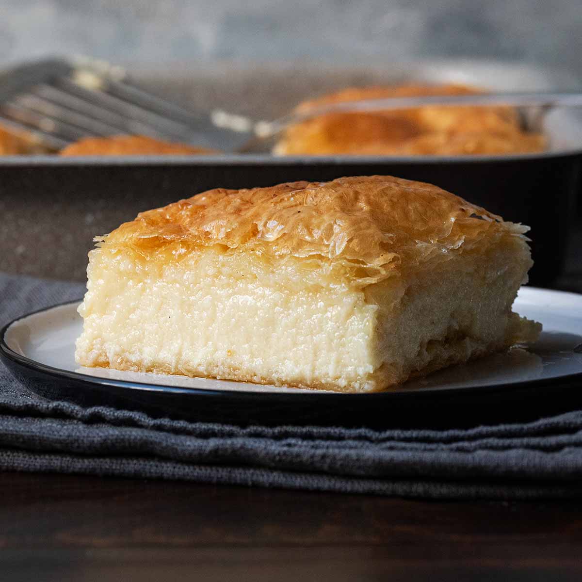A slice of Greek galaktoboureko with crispy phyllo and custard cream.