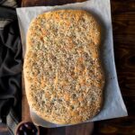 Greek Lagana flatbread on a piece of parchment paper.