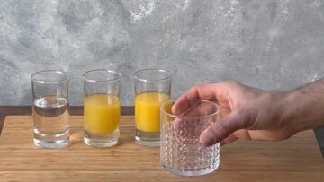 A hand holding an old fashioned glass.