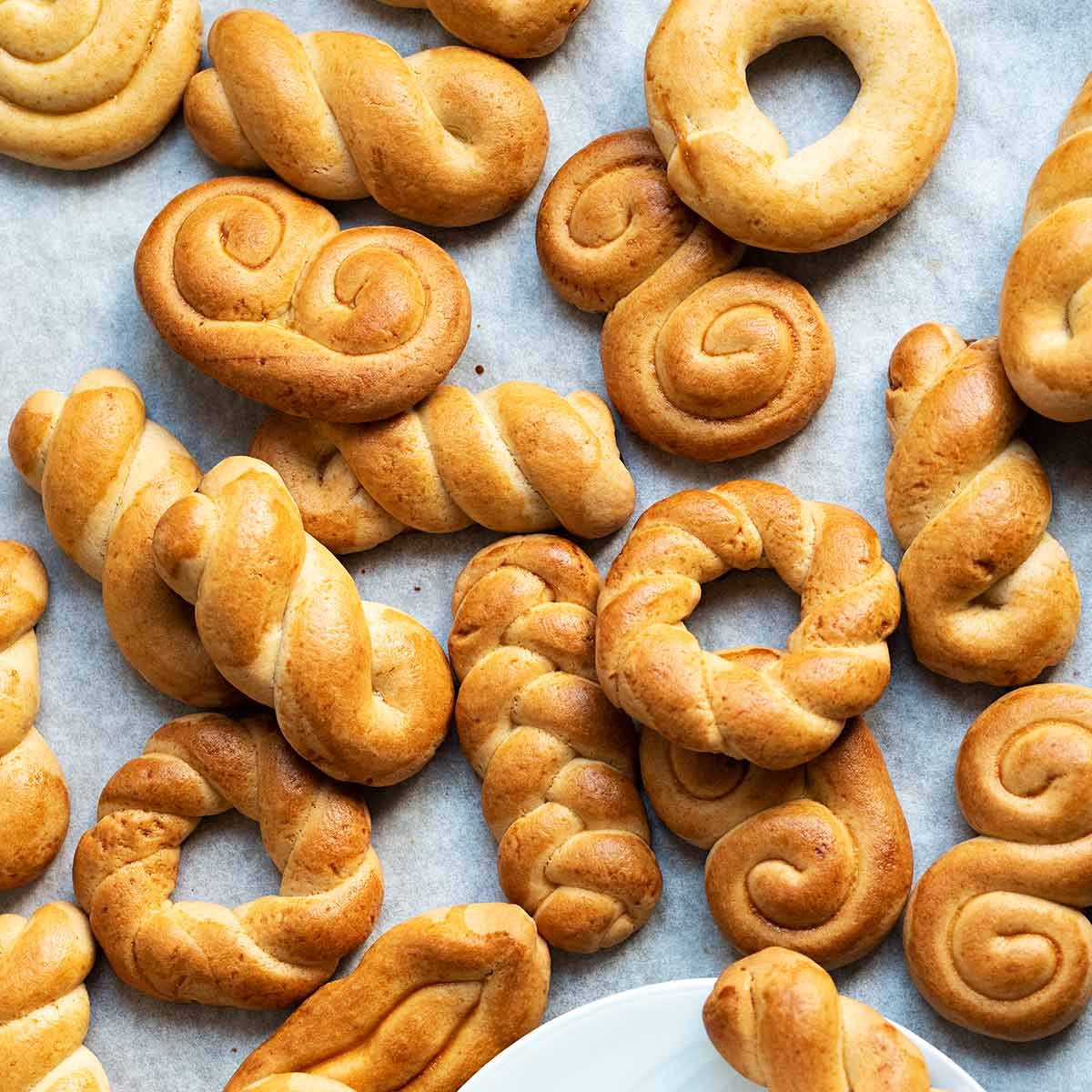 Koulourakia cookies on parchment paper.