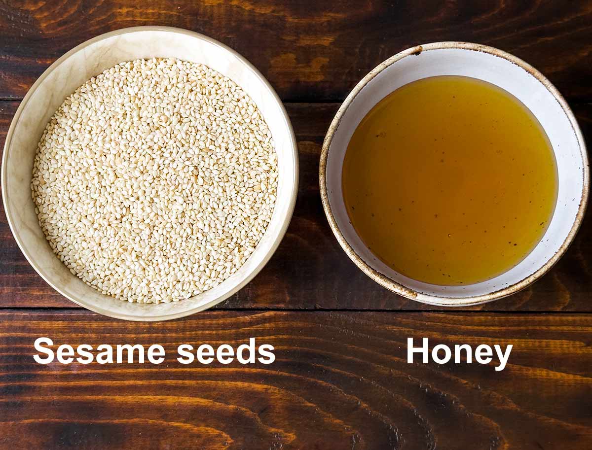 Two bowls, one with honey and one with sesame seeds with text labels.