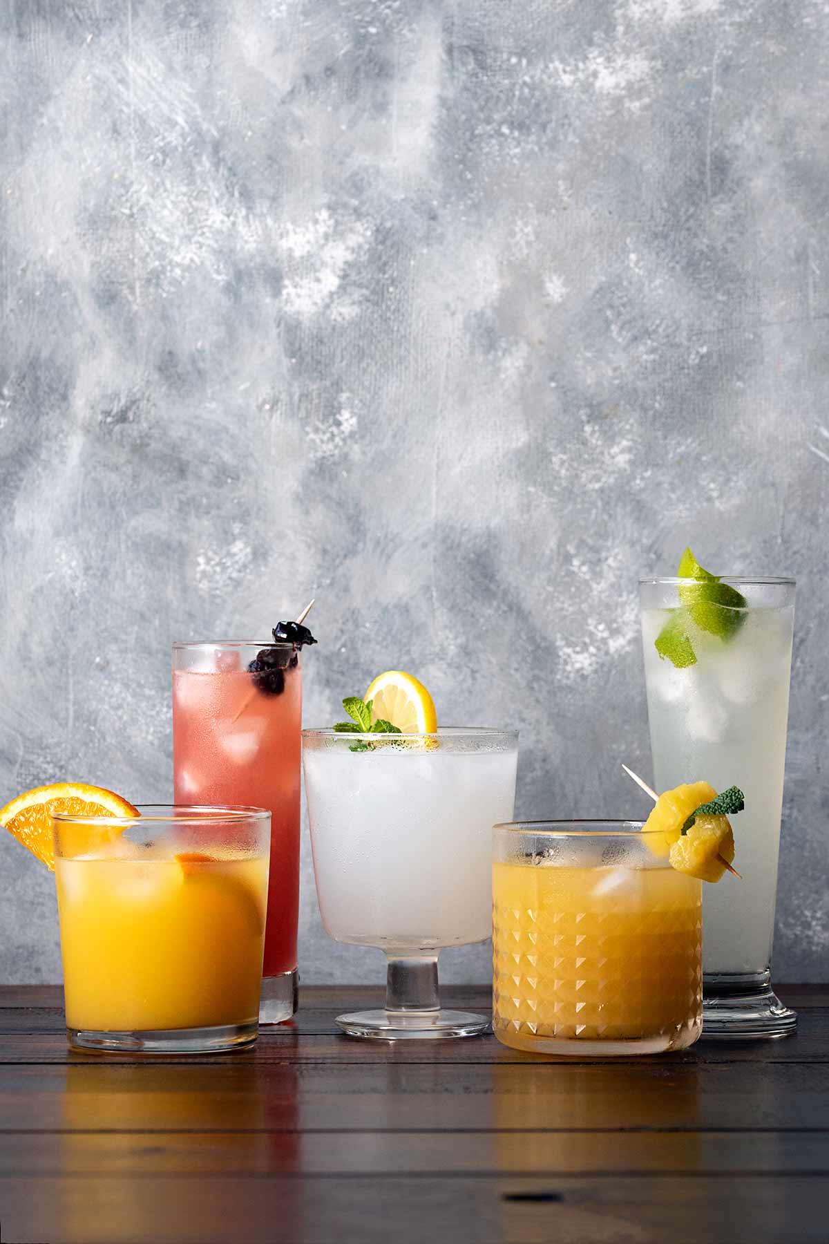 Five Ouzo cocktails on a wooden surface.