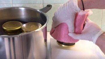Two hands taking the jars out of the pot.