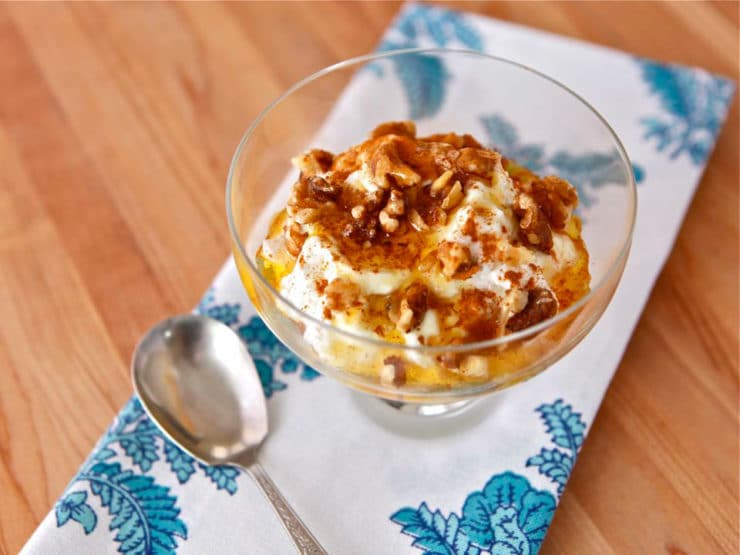 A bowl with Greek yogurt, honey and walnuts.