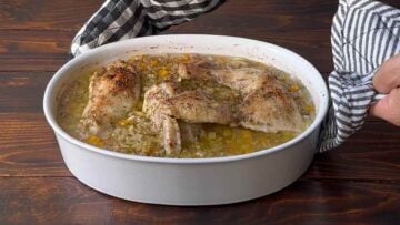 Baked chicken and orzo in a casserole dish.