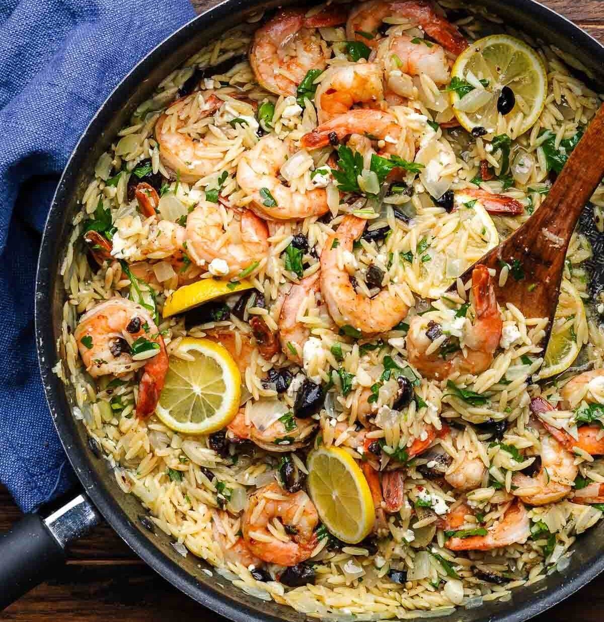 Orzo with shrimp and feta cheese in a skillet.