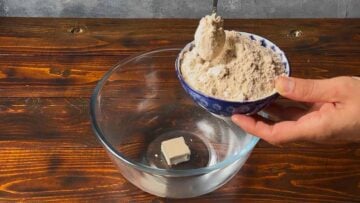 A bowl with water and yeast and a bowl with flour.