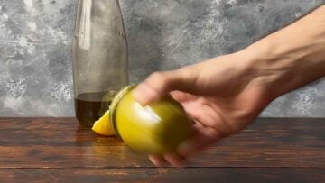 A hand shaking a jar with olive oil and lemon juice.